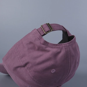 Detail of purple cotton baseball cap with adjustable bronze buckle and twill texture