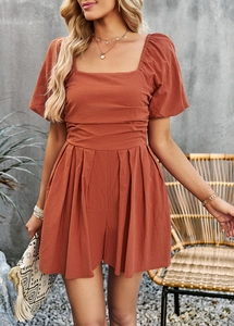 Detail of auburn romper featuring square neck, short sleeves, and pleated waist design