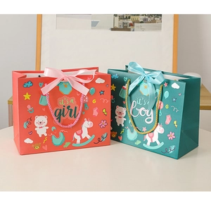 Detail of coral and teal baby shower gift bags with ribbons and it's a boy/girl text