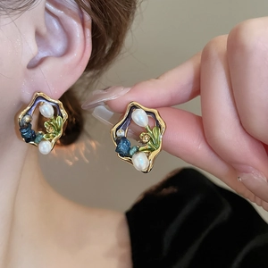 Detailed close-up of French vintage gold-plated pearl flower earrings with colorful enamel