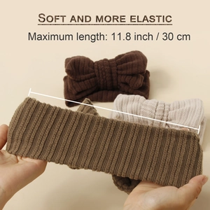 Three plush elastic knitted baby headbands with bows showing 30cm stretch length