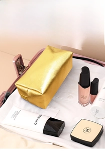 Golden waterproof travel cosmetic bag inside a suitcase for convenient organization