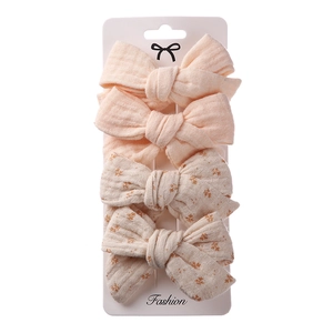 Detail of four-piece linen hair bow set with floral and pink patterns on display card