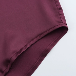 Detailed macro view of the dark red stretch fabric and stitching on the swimsuit crotch