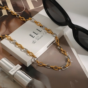 Two-tone gold and silver stainless steel link necklace styled on a fashion magazine