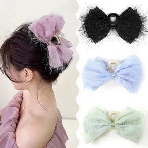 Detailed view of large chiffon bow hair clips in purple, black, blue, and green colors