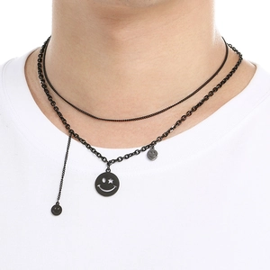 Double-layered black smiley face pendant necklace with star charms on model neck