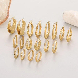 Flat lay of multiple irregular 18K gold-plated stainless steel hoop earrings collection