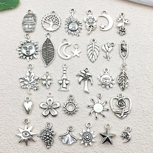 Flat lay of mixed antique silver alloy pendants with sun, moon, and nature motifs for DIY