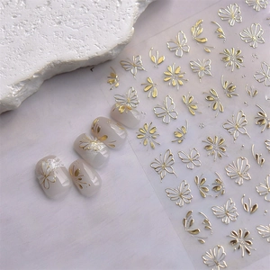 Detailed view of gold metallic nail stickers featuring elegant butterfly and floral patterns
