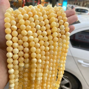 Natural yellow jade round beads for DIY jewelry making shown in natural outdoor light