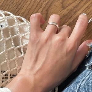 Minimalist 925 sterling silver wavy ring worn on hand over a natural lifestyle background