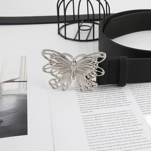 Detail of a vintage black leather belt featuring a large silver butterfly buckle