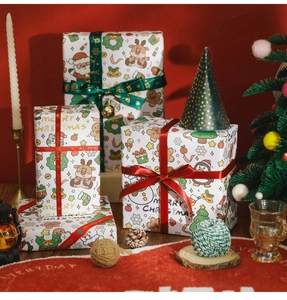 Detailed view of Christmas wrapping paper with Santa patterns, festive ribbons, and bells