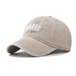 Detail of PARIS embroidery on washed cotton beige baseball cap with vintage texture