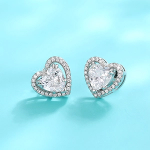 Exquisite silver heart stud earrings with halo crystals on a light blue background