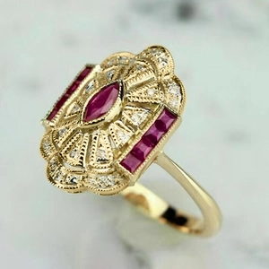 Vue macro d'une bague Art Déco avec pierre rouge marquise et détails fins en milgrain