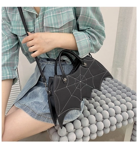 Detail view of the black bat-shaped PU bag featuring white spider web stitching detail