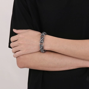 Detail of retro punk skeleton bike chain bracelet in antique silver on male wrist
