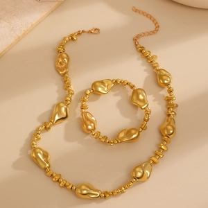 Détail de l'ensemble collier et bracelet dorés aux perles de lave texturées baroques