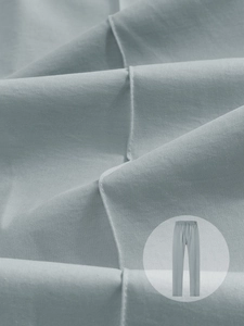 Gros plan sur la texture du tissu en sergé bleu clair et les coutures du pantalon