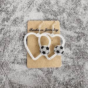 Vue détaillée des boucles d'oreilles cœur argentées à paillettes avec motif de ballon de foot