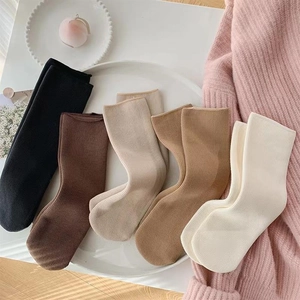 Close-up of five pairs of thick thermal snow socks in earth tones on a white tray