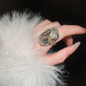 Close-up of a large rectangular crystal ring with silver multi-claw setting on hand