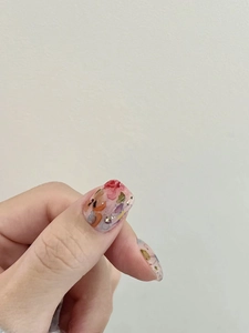 Makro-Detail von Aquarell-Marmor-Nagelkunst mit Blumenmustern und goldenem Glitzer