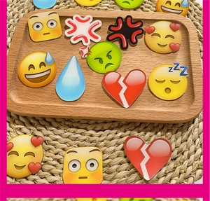 Macro shot of colorful emoji acrylic charms and brooches on a rustic wooden tray