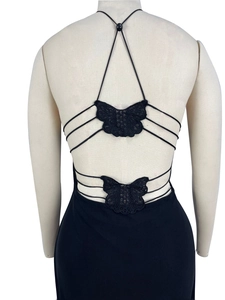 Detail of cross straps and black lace butterfly appliques on a backless mesh dress
