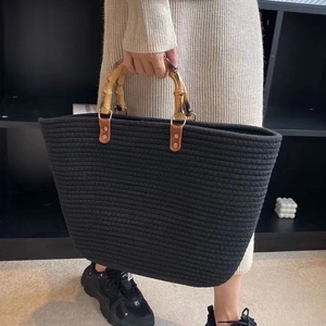 Detail of woven tote bag with carbonized bamboo handles and leather rivet fasteners
