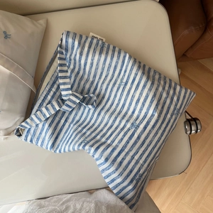 Détail du sac cabas en coton à rayures bleues et blanches avec broderie nœud et étiquette