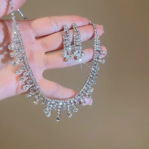 Close-up detail of silver water-drop tassel jewelry set with sparkling rhinestones on hand