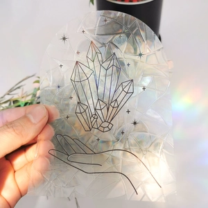 Close-up of suncatcher window decal with crystal design creating rainbow prism reflections