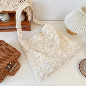 Close-up of cream white lace tote bag featuring elegant triple-layered ruffled edges