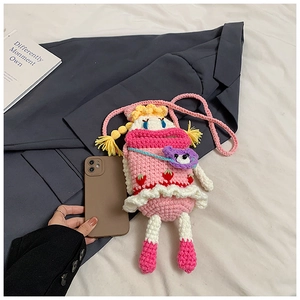 Close-up of handmade pink crochet doll bag showing size scale with a phone case