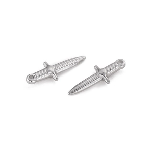 Macro detail of two silver stainless steel dagger pendants for jewelry making
