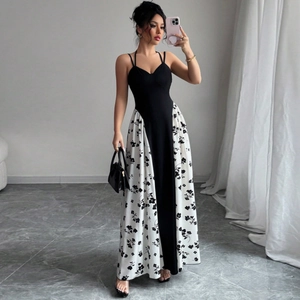 Détail d'une robe longue dos nu avec haut noir et jupe imprimée de fleurs blanches