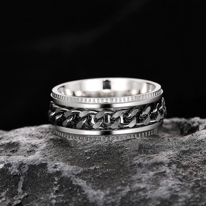Macro detail of industrial rotatable chain ring on black rock with gear textured edges