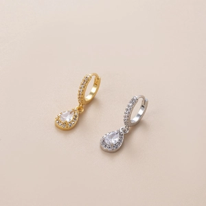 Macro shot of gold and silver teardrop zircon earrings with shimmering pave rhinestones