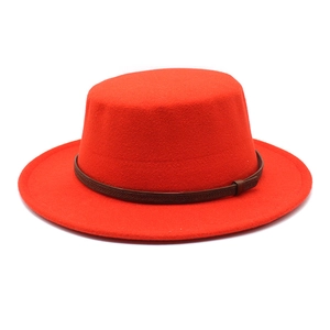 Détail d'un chapeau canotier en laine rouge avec bande décorative tressée marron