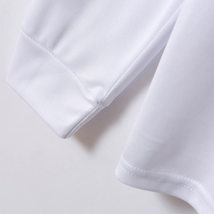 Close-up of white long sleeve polo shirt showing ribbed cuffs and fine mesh texture