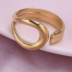 Macro detail of adjustable gold curved geometric ring on a soft velvet display