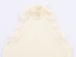 Dettaglio del top senza maniche con pizzo floreale sullo scollo alto color crema