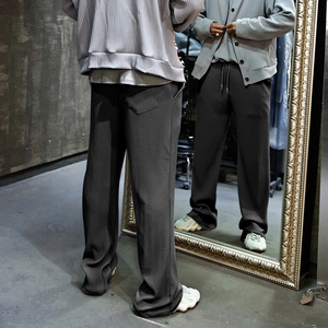 Mirror view of dark grey wide leg trousers showing texture and drawstring waist detail