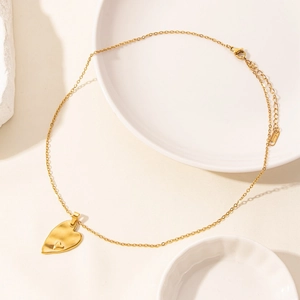 Detail of 18k gold plated heart pendant necklace with textured brushed stainless steel finish