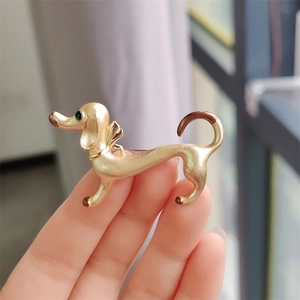 Creative enamel dachshund dog brooch in golden metal with brown accents and green eye detail