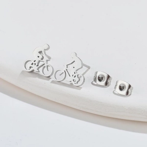 Minimalist silver bicycle stud earrings in stainless steel on a white platform