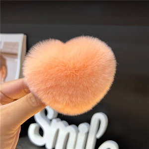 Close-up of orange plush heart hair clip showing soft rabbit fur texture and detail